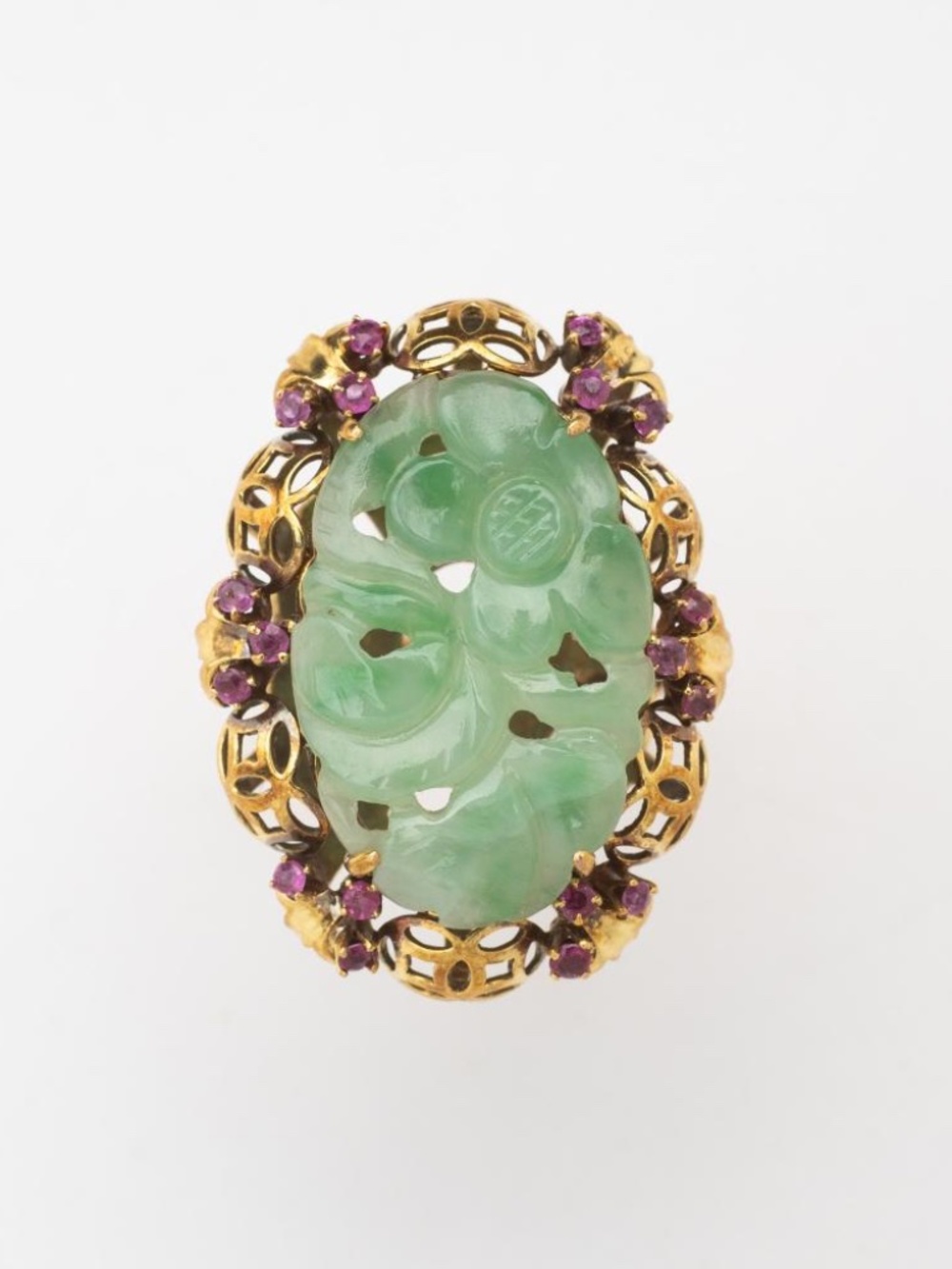 A Chinese carved jadeite and ruby ring set in 14kt yellow gold